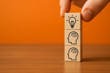 A hand places a wooden cube with a lightbulb icon on top of two cubes with brain icons on a wooden surface against a burnt orange background, concept for brainstorming and innovative ideas