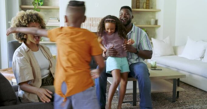 Diverse family in living room welcoming children running in, hugging kids, posing and laughing