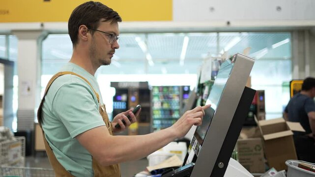 Man shopper enters his phone number to get a discount at a self-checkout in a hardware store