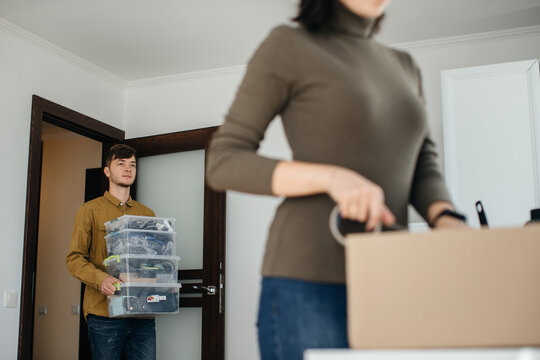 Young couple moving into new apartment carrying boxes