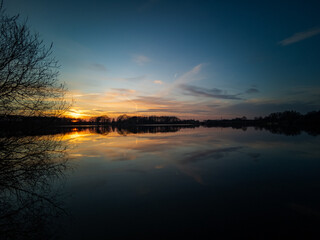 Fototapeta premium Sunset on a calm lake, with reflection in the water