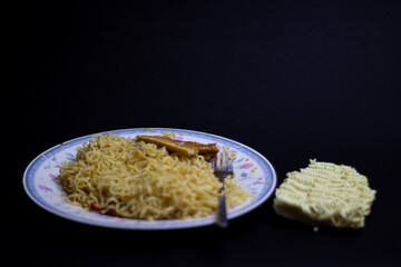 A classic Indonesian instant noodle meal, perfect for budget-friendly student life. Quick, delicious, and a dormitory staple. Isolated black background