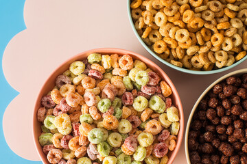 Different types of breakfast cereal. Chocolate balls, round cereals and colourful rings. 