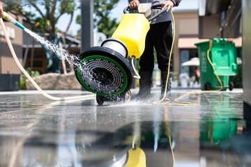 Workers are cleaning the road with a floor scrubber