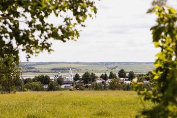 the Church of St. John the Theologian in the village of Karamyshevo built in 1888 and the valley of the Anish River on a sunny summer day