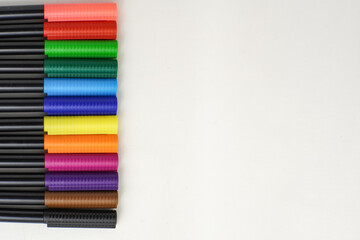 Colorful markers neatly arranged in vertical line on white background, ideal for school supplies,...