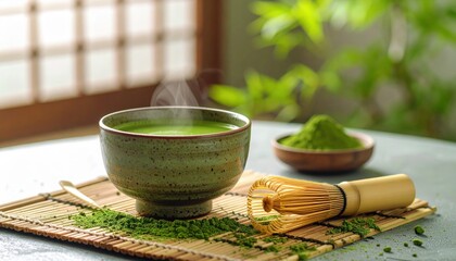 A serene setting featuring a traditional bowl of steaming matcha green tea next to powdered matcha and a bamboo whisk on a bamboo mat.