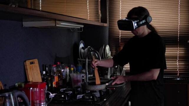 A mid-shot captures a quirky and futuristic mood as a person, wearing a VR headset, cooks at a gas stove in a kitchen, blending domesticity with advanced technology