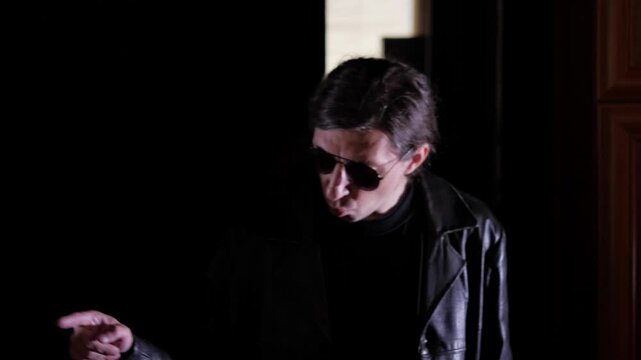 Menacing and authoritative mood as a person, dressed like a mobster in sunglasses and a leather jacket, points their finger with a stern expression, suggesting a threat or warning directed at someone