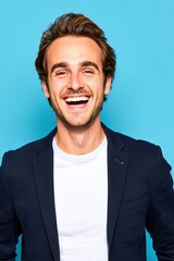 Cheerful male influencer in white t-shirt and blazer, mid-laugh, soft blue background