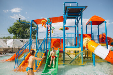 Children playing on colorful water slides in aqua park