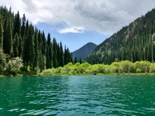 Kolsai Lake in Kazakhstan – Crystal-Clear Mountain Lake Surrounded by Forested Slopes and Alpine Peaks.