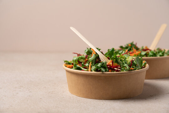 Healthy salad with carrot and beetroot in craft bowl on beige background with copy space. Vegan, diet, food delivery concept