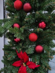 Red Christmas balls on the branches of an artificial Christmas tree