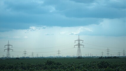 Power line pylons under stormy sky