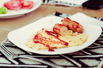 plate of unhealthy junk food for breakfast, scrambled eggs, sausages, ketchup