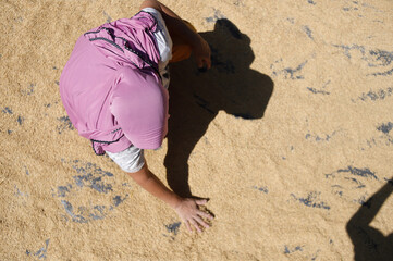 Fototapeta premium Farmer Drying Paddy Rice Under the Sun