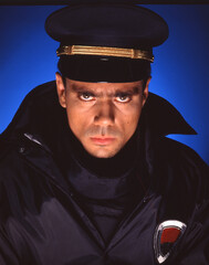 Serious expression of police man portrait wearing hat. 