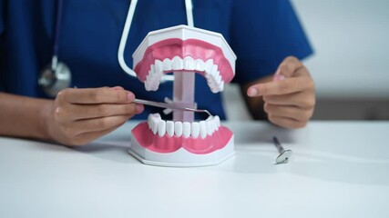 dentist video consultation, communicates with patient via an online conference, uses laptop, diagnoses, recommended and tooth models and analyzing dental treatments, and also answers questions. - Powered by Adobe