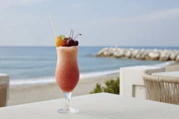 refreshing cocktail named fruit fantasy elegantly placed on white table beside sea