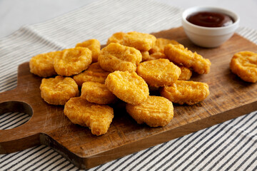 Organic Fried Chicken Nuggets on a wooden board, side view. Close-up.