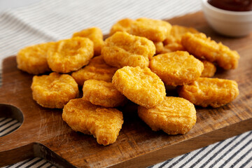 Organic Fried Chicken Nuggets on a wooden board, side view. Close-up.