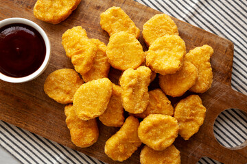 Organic Fried Chicken Nuggets on a wooden board, top view. Close-up.