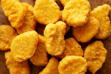 Organic Fried Chicken Nuggets on a wooden board, top view. Close-up.