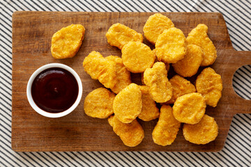 Organic Fried Chicken Nuggets on a wooden board, top view. Close-up.