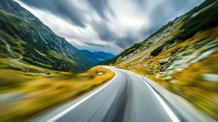 Motion blur effect on a curving mountain road with sharp turns, creating the feeling of speed and thrilling movement