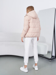 Fashion model showcases stylish winter attire in modern studio setting