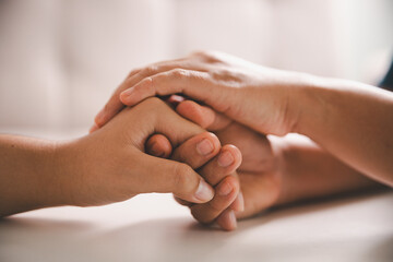 Hope and trust with crisis concept. Closeup, love and holding hands for support, comfort and care with grief, loss and empathy. people and family with compassion, sympathy and healing with bonding.