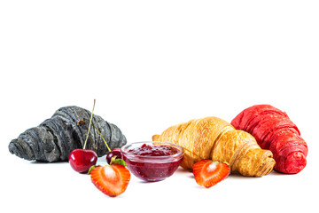 Classic, red and black croissants, jam and berries isolated on white.