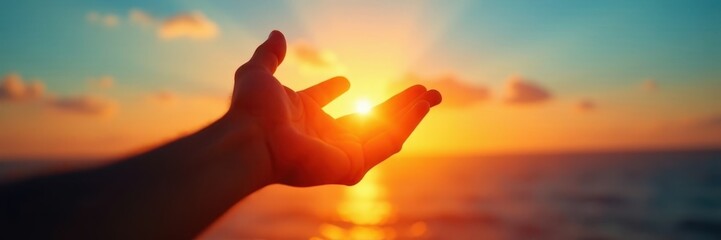 Silhouetted hand outstretched towards a setting sun, azure sky backdrop , nature, outdoor