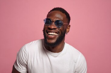 Obraz premium Man laughing with sunglasses against pink backdrop