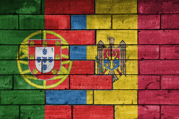 colourful painted big national flag of moldova and flag of portugal on a massive old brick wall background. concept