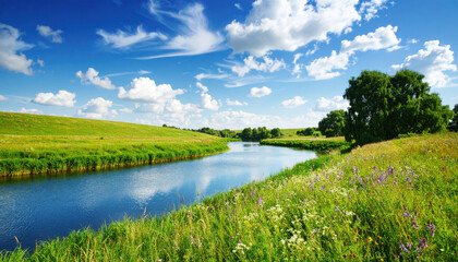 Serene Summer Landscape with a Meandering River Through Green Hills and Wildflowers Under a Bright Blue Sky with Clouds, Evoking Tranquility