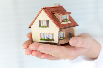 House in human hands on a white background...