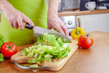 Woman chopping lettuce on cutting board...