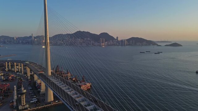 Aerial view of Stonecutters Bridge crossing the bay and container port at sunset in Hong Kong, 4k