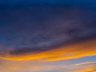 Golden twilight sky with faint cloud streaks.Color-splashed at sunset with warm hues. 