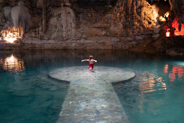 Caucasian woman performing a ritual in a magical cenote in magic town, yucatan, mexico