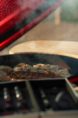 The meat is grilled on a portable charcoal grill