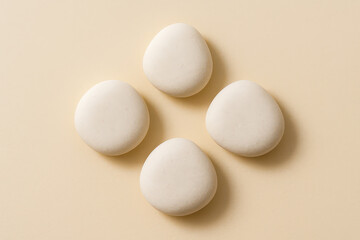 White Pebbles Arranged in Diamond Formation on Beige Background