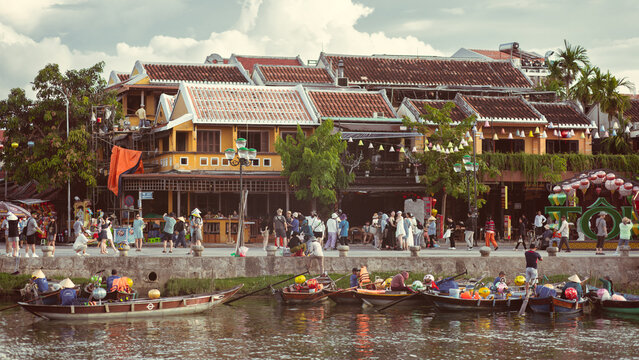 Fototapeta Riverside View Of Hoi An With Traditional Boats And Historic Yellow Houses