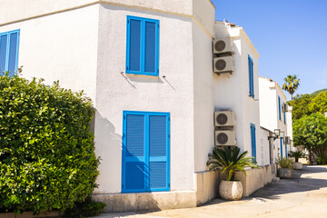 White houses with blue shutters. Mediterranean design, summer climate adaptation, and coastal urban...