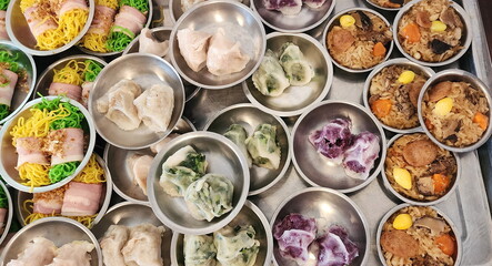 A variety of  dim sum dishes are arranged in stainless steel cups for customers to choose from. Small dishes, mostly steamed before eating. Brunch is often served with sweet - sour sauce. fusion food
