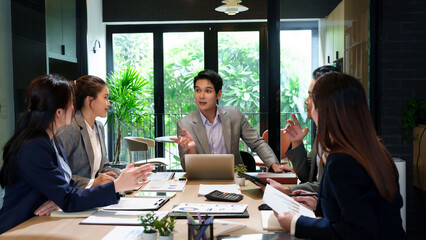 Asian Business Team Meeting Brainstorming Ideas in Modern Office Space Collaborative Project Discussion with Young Professionals and Laptop