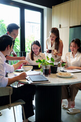 Asian Professionals Collaborate in Modern Office Enjoying Casual Meeting with Snacks and Drinks Discussing Business Ideas in Thailand