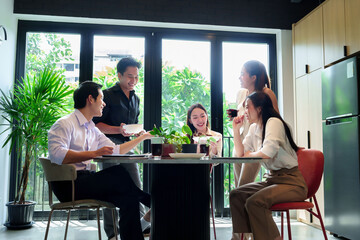 Asian Professionals Enjoying Casual Gathering with Food and Drinks During Break Time in Bright Modern Office